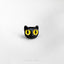 a close up of a black cat's face with yellow eyes