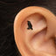 A small black bird-shaped earring is visible in the person's ear.
