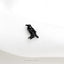 a small black bird sitting on top of a white cloth