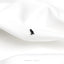 a black bird sitting on top of a white sheet