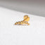 A single gold-colored earring with a curved design sits on a white surface.