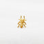 a gold spider ring sitting on top of a white sheet