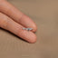 a person's hand holding a tiny silver ring