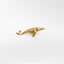a gold brooch depicting a fish on a white background