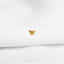 a gold bee pin sitting on top of a white sheet