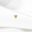 a close up of a white shirt with a gold heart pin