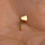 A small gold-colored metal object resembling a miniature axe is being held in a person's hand.