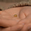 a baby's hand holding a tiny gold ring