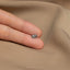 a person's hand holding a tiny diamond ring