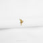 a small gold pin sitting on top of a white cloth