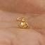 A small gold-colored charm in the shape of a monkey is being held in someone's hand.