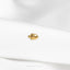 a close up of a gold ring on a white shirt