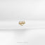 a gold heart pin sitting on top of a white cloth