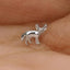 A small silver fox figurine is resting on a person's hand.