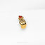 a gold brooch with a red heart on it
