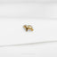 a small gold dog pin sitting on top of a white sheet