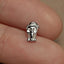 a person's finger with a small silver elephant charm on it