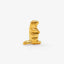 A small, golden figurine of a meerkat standing upright on its hind legs.