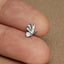 a person's finger with a tiny silver bird ring on it