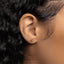a close up of a person's ear wearing a gold earring