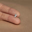 a person's hand holding a tiny silver butterfly ring