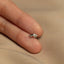a person's hand holding a tiny silver ring