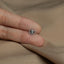 a person's hand holding a tiny silver ring