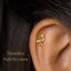 A gold-colored earring with a small bird-like design is visible in the image.