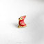 a red bird pin sitting on top of a white surface
