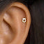 A gold-colored earring with a star-shaped cutout is visible in the person's ear.