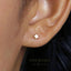 A close-up of a person's ear with a small gold star-shaped earring in it.