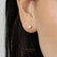 A close-up view of a person's ear with a small gold-colored earring.