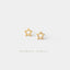Two gold star-shaped earrings are displayed against a white background.