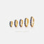 a collection of gold earrings with blue gemstones, arranged in a row.