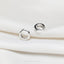 a pair of silver rings sitting on top of a white cloth