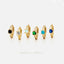 A collection of six gold earrings with gemstones, arranged in a row against a white background.
