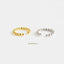 Two rings with a metallic texture, one gold and one silver, are placed side by side against a white background.