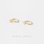two gold hoop earrings with small white stones, arranged on a white background.