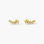 A pair of gold earrings with small, clear stones or diamonds arranged in a decorative pattern.