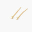 Two gold earrings with a star and a crescent moon charm hanging from the chain.