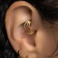 A close-up of a person's ear with a gold hoop earring visible.