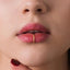 A close-up of a person's lips with a gold ring piercing in the middle of the lip.