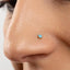 A close-up of a person's nose with a small turquoise stone nose stud.