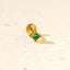 A single gold earring with a green gemstone is shown against a plain white background.