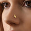 A close-up of a person's face, focusing on their nose and the gold-colored nose ring.