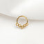 A gold-colored metal ring with a hexagonal design, resting on a white surface.