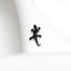a small black lizard sitting on top of a white cloth