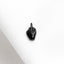 a small black object sitting on top of a white cloth
