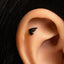 A small black bat wing piercing in the ear.