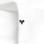 a close up of a white shirt with a black butterfly on it